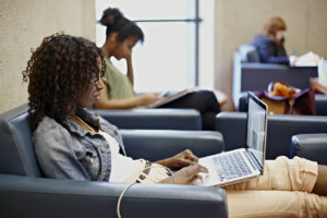 girl on a laptop sitting on a sofa chair