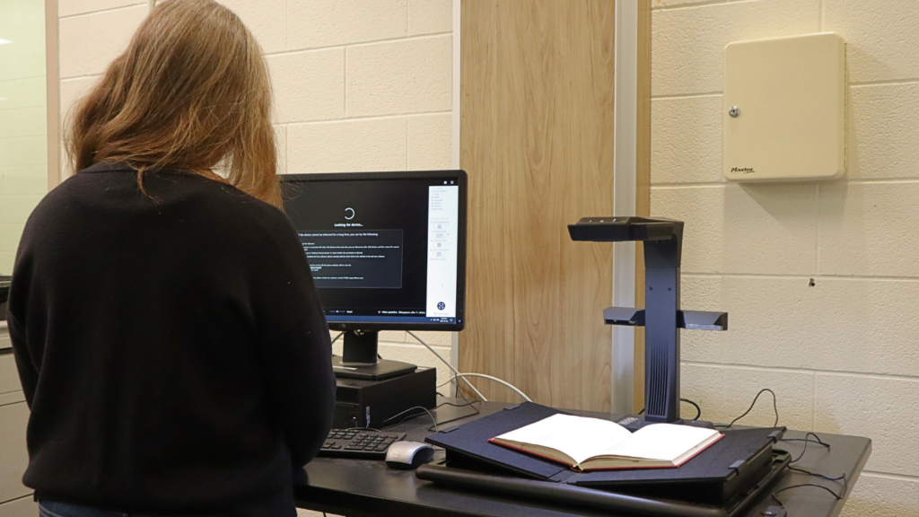 Libraries staff at scanner scanning a book page